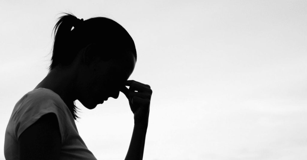 woman grasping the bridge of her nose
