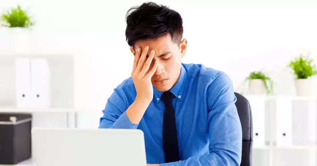 Man holding head related to caffeine and migraine
