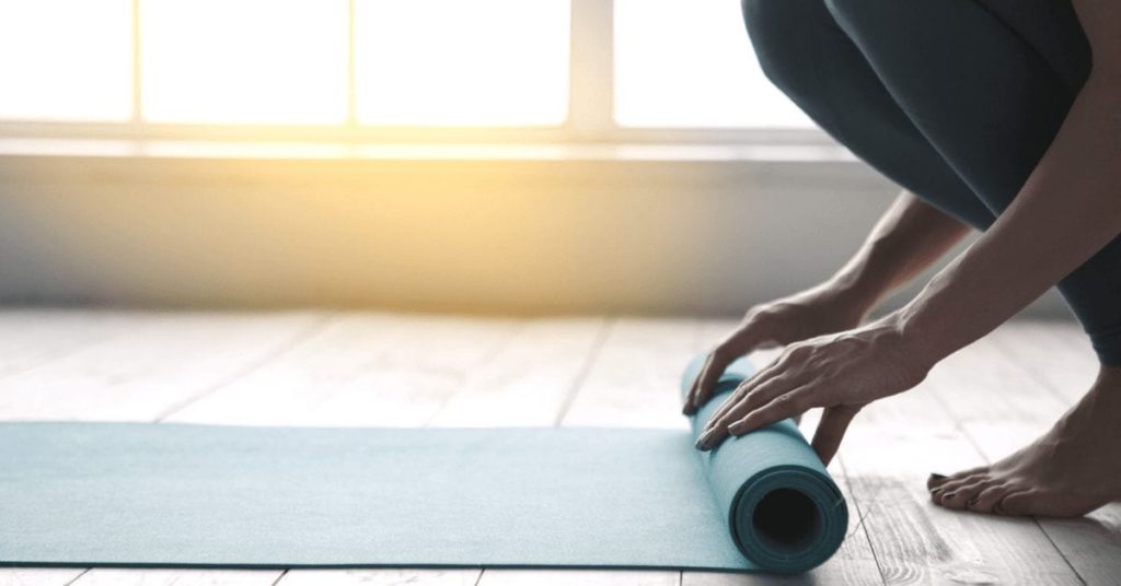 woman unrolling yoga mat