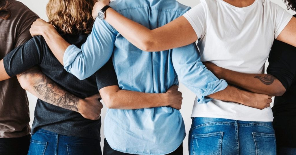 people's backs with arms around each other