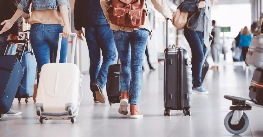 prople rolling suitcases while travelling for the holidays