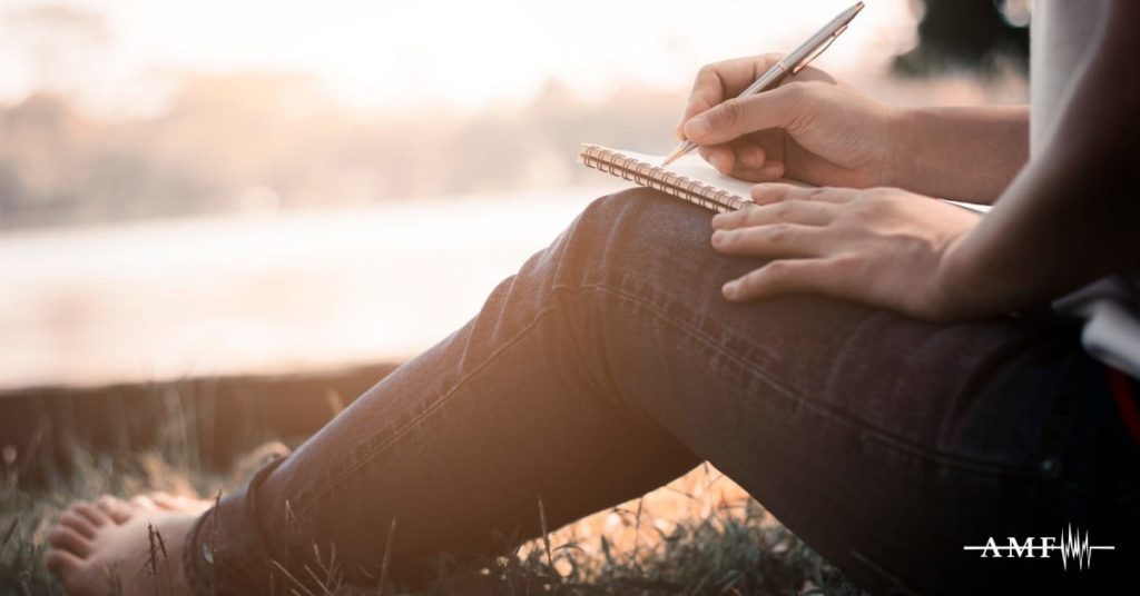 person writing in headache journal